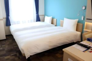 a bed with white sheets and a table in a room