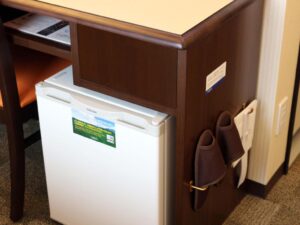 a small white refrigerator on a wooden surface