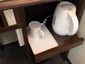 a white kettle and a mug on a tray